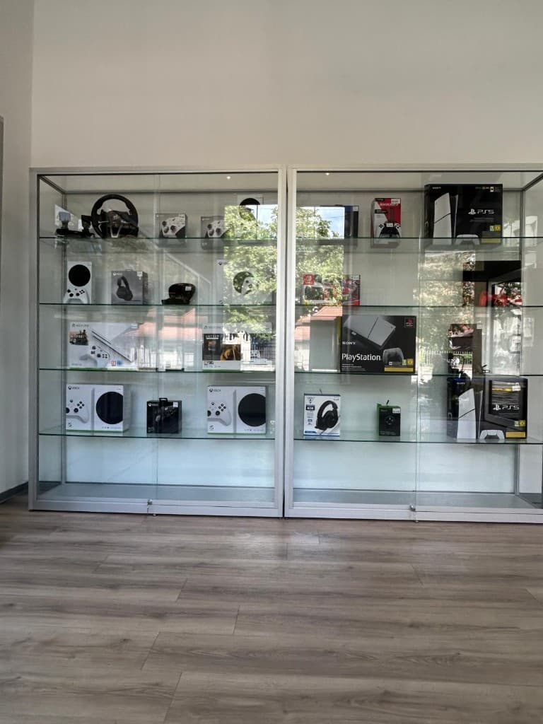 Glasvitrinen mit Xbox und PlayStation Konsolen