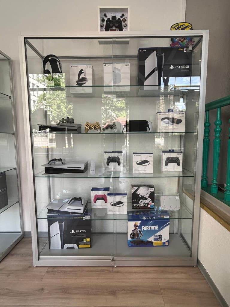 Vitrine mit PlayStation 5 Pro, PS4, Nintendo Switch und Zubehör